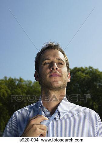 Office worker loosening his necktie View Large Photo Image Picture - Office worker loosening his necktie. Fotosearch