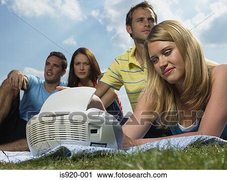 Stock Image - People listening to music in a park. Fotosearch