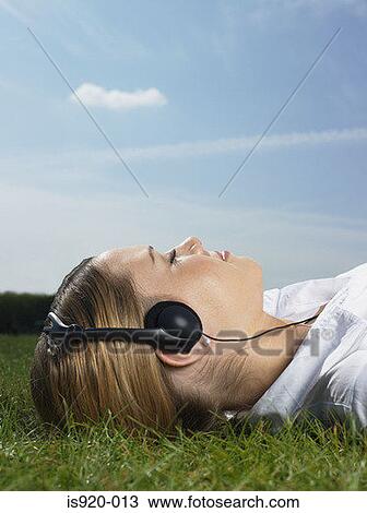 Woman listening to music in a park View Large Photo Image Stock Image - Woman listening to music in a park. Fotosearch