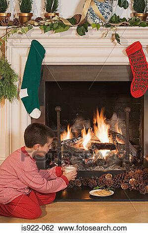 Boy by fireplace at christmas View Large Photo Image Stock Image - Boy by fireplace at christmas. Fotosearch