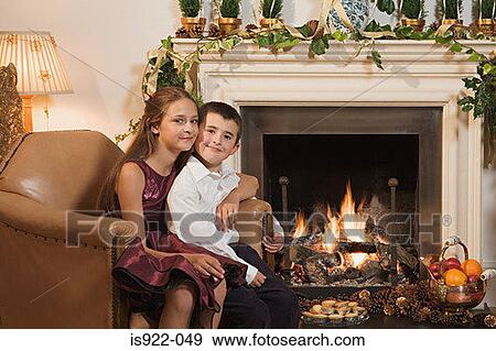 Stock Photo - Children by fireplace at christmas. Fotosearch