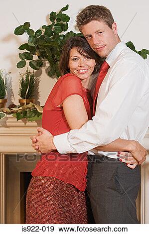 Couple hugging by fireplace View Large Photo Image Stock Photo - Couple hugging by fireplace. Fotosearch