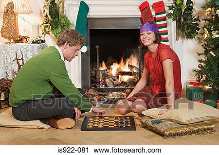 Stock Image - Couple playing chess at christmas. Fotosearch