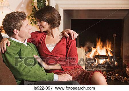 Stock Photo - Couple resting by fireplace. Fotosearch
