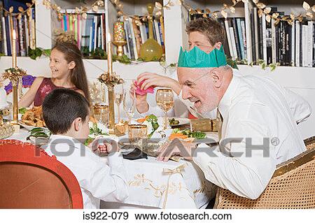 Stock Photo - Family at dining table at christmas. Fotosearch