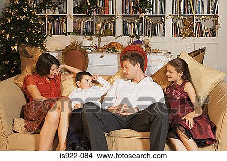 Picture - Family on sofa at christmas. Fotosearch