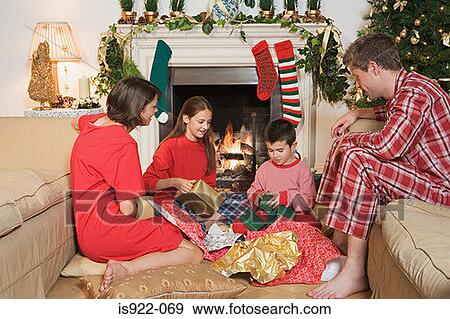 Stock Photo - Family opening christmas presents. Fotosearch