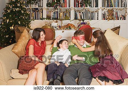 Stock Image - Family playing on sofa at christmas. Fotosearch