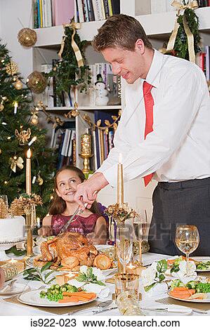 Stock Image - Father and daughter at dining table. Fotosearch