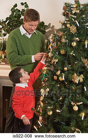Father and son decorating a christmas tree View Large Photo Image Stock Photo - Father and son decorating a christmas tree. Fotosearch