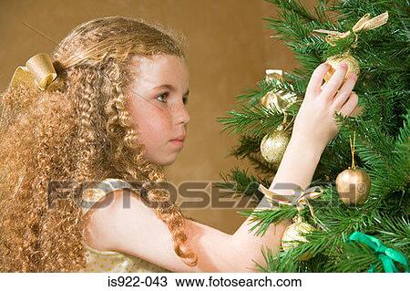 Girl decorating a christmas tree View Large Photo Image Stock Image - Girl decorating a christmas tree. Fotosearch