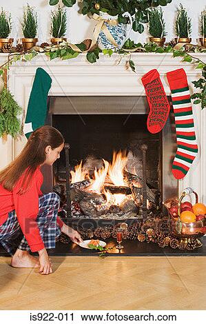 Girl placing festive items by fireplace View Large Photo Image Stock Image - Girl placing festive items by fireplace. Fotosearch