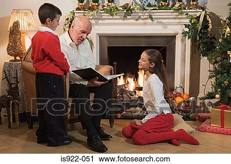 Stock Image - Grandfather telling children a story. Fotosearch