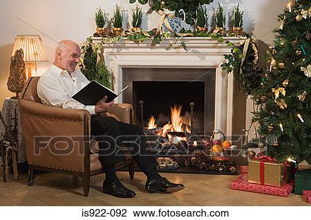 Man reading a book at christmas View Large Photo Image Stock Image - Man reading a book at christmas. Fotosearch