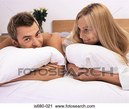 Couple relaxing in bed View Large Photo Image Stock Image - Couple relaxing in bed. Fotosearch