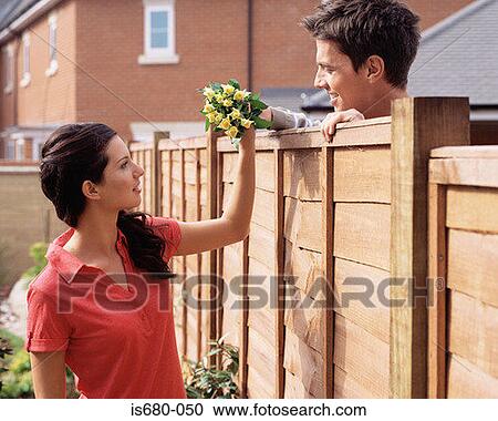 Man giving flowers to his neighbour View Large Photo Image Stock Image - Man giving flowers to his neighbour. Fotosearch