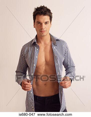 Man putting on a shirt View Large Photo Image Stock Photo - Man putting on a shirt. Fotosearch