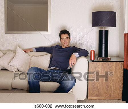 Man watching television on sofa View Large Photo Image Stock Image - Man watching television on sofa. Fotosearch