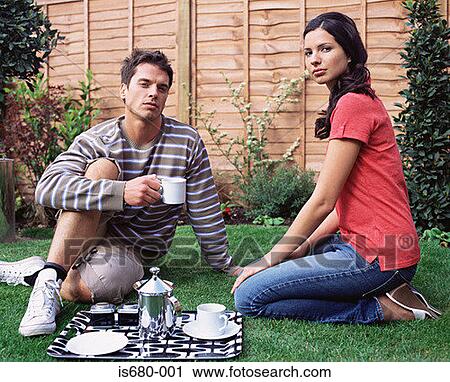 Stock Image - Young couple having coffee in the garden. Fotosearch