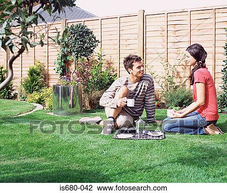Young couple having coffee in the garden View Large Photo Image Stock Image - Young couple having coffee in the garden. Fotosearch