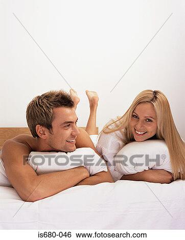 Young couple in bed View Large Photo Image Stock Photograph - Young couple in bed. Fotosearch