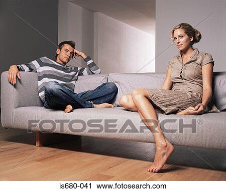Stock Image - Young couple sitting on a sofa. Fotosearch