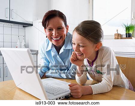 Stock Image - Mother and daughter using laptop computer. Fotosearch