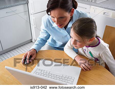 Stock Image - Mother and daughter using laptop computer. Fotosearch