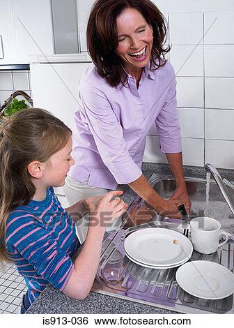 Stock Photograph - Mother and daughter washing up. Fotosearch