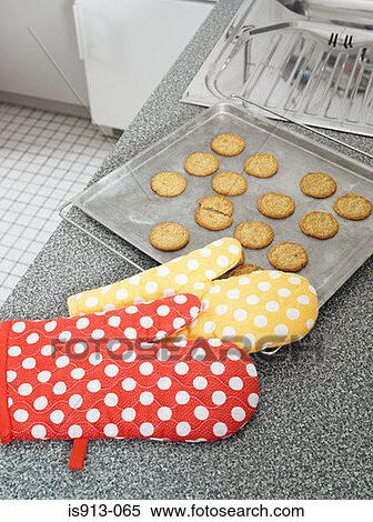 Oven gloves by tray of biscuits View Large Photo Image Stock Photography - Oven gloves by tray of biscuits. Fotosearch