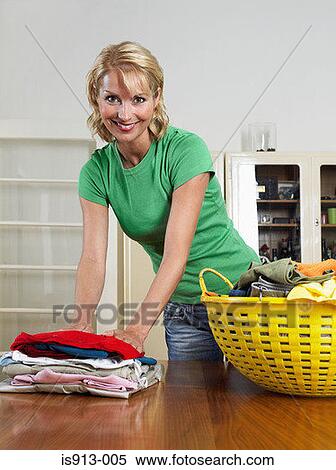 Stock Photography - Woman folding laundry. Fotosearch