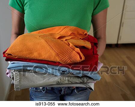 Woman holding pile of clothes View Large Photo Image Stock Photography - Woman holding pile of clothes. Fotosearch