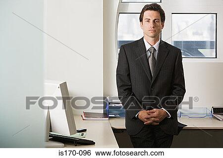 Businessman sitting on a desk View Large Photo Image Stock Photograph - Businessman sitting on a desk. Fotosearch