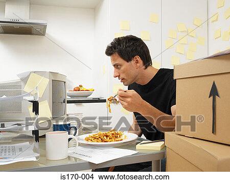 Man working and eating dinner View Large Photo Image Picture - Man working and eating dinner. Fotosearch