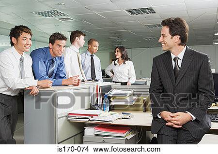 Picture - Manager chatting to employees. Fotosearch