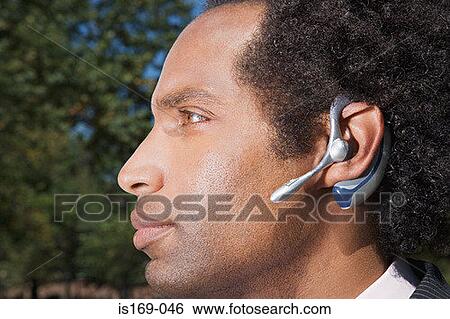 Businessman wearing a bluetooth headset View Large Photo Image Stock Photograph - Businessman wearing a bluetooth headset. Fotosearch