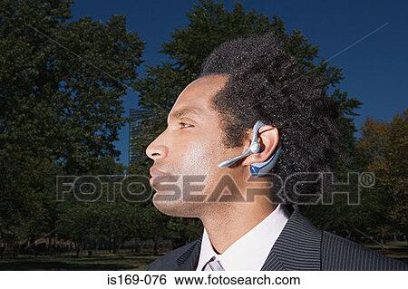 Stock Photograph - Businessman wearing a bluetooth headset. Fotosearch