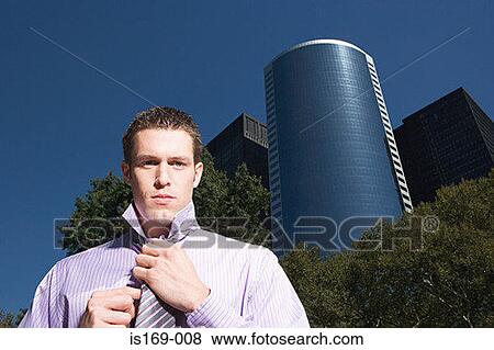Stock Photo - Male office worker adjusting necktie. Fotosearch