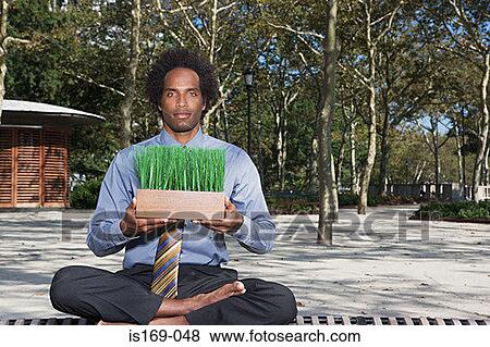 Stock Photo - Man meditating in a park. Fotosearch