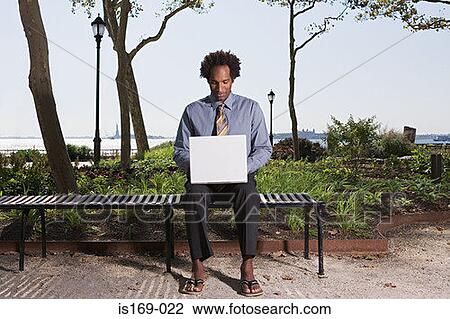Man telecommuting in a park View Large Photo Image Stock Image - Man telecommuting in a park. Fotosearch