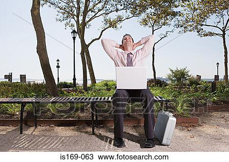 Man telecommuting in a park View Large Photo Image Stock Image - Man telecommuting in a park. Fotosearch