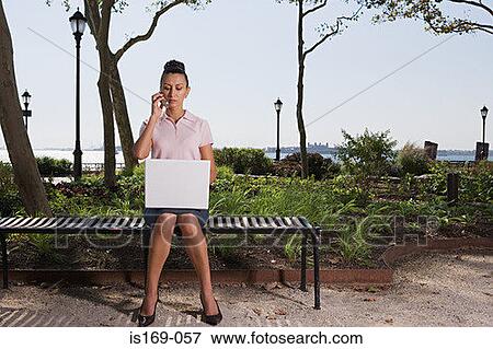 Woman telecommuting in a park View Large Photo Image Stock Photo - Woman telecommuting in a park. Fotosearch