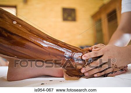 Applying oil to womans leg View Large Photo Image Stock Photo - Applying oil to womans leg. Fotosearch