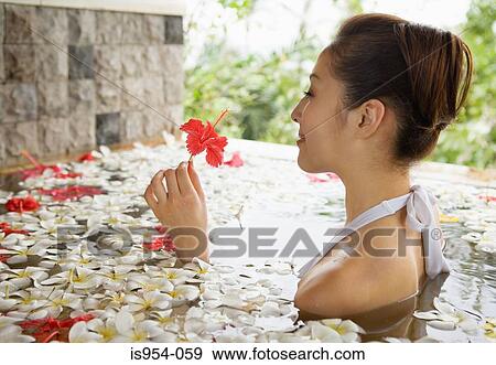 Stock Photo - Woman in pool with flowers. Fotosearch