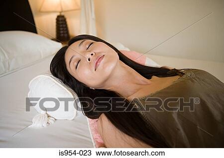 Stock Image - Woman lying on bed. Fotosearch