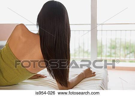 Stock Photograph - Woman lying on bed. Fotosearch
