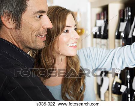 Couple looking at wine bottles View Large Photo Image Stock Image - Couple looking at wine bottles. Fotosearch