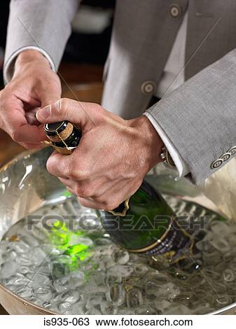 Man opening champagne bottle View Large Photo Image Stock Image - Man opening champagne bottle. Fotosearch