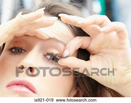 Woman applying fake eyelashes View Large Photo Image Stock Photo - Woman applying fake eyelashes. Fotosearch