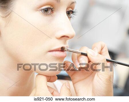 Stock Image - Woman having lipgloss applied. Fotosearch
